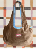 Brown bag with a pink label on a patterned wall background