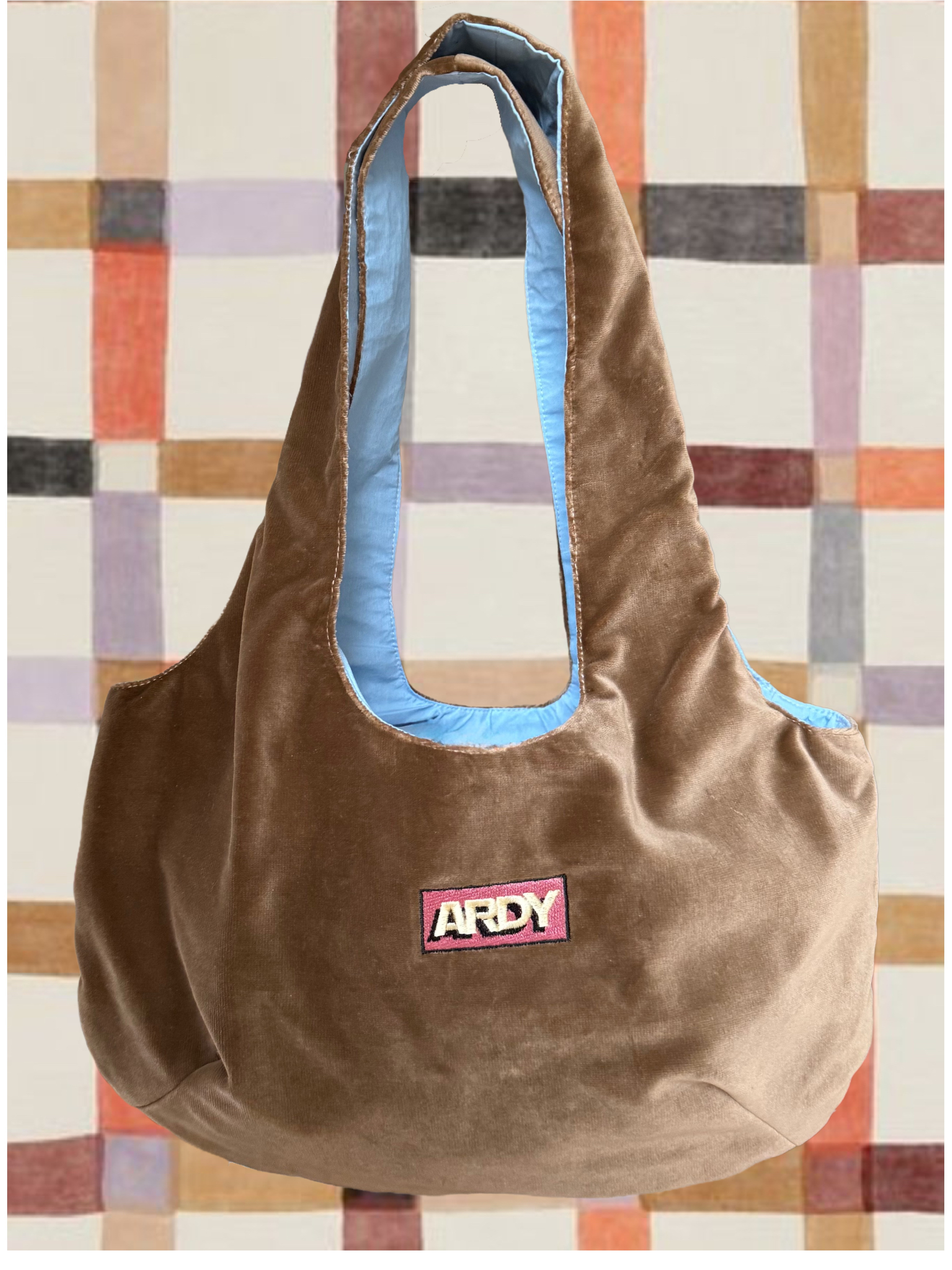 Brown bag with a pink label on a patterned wall background